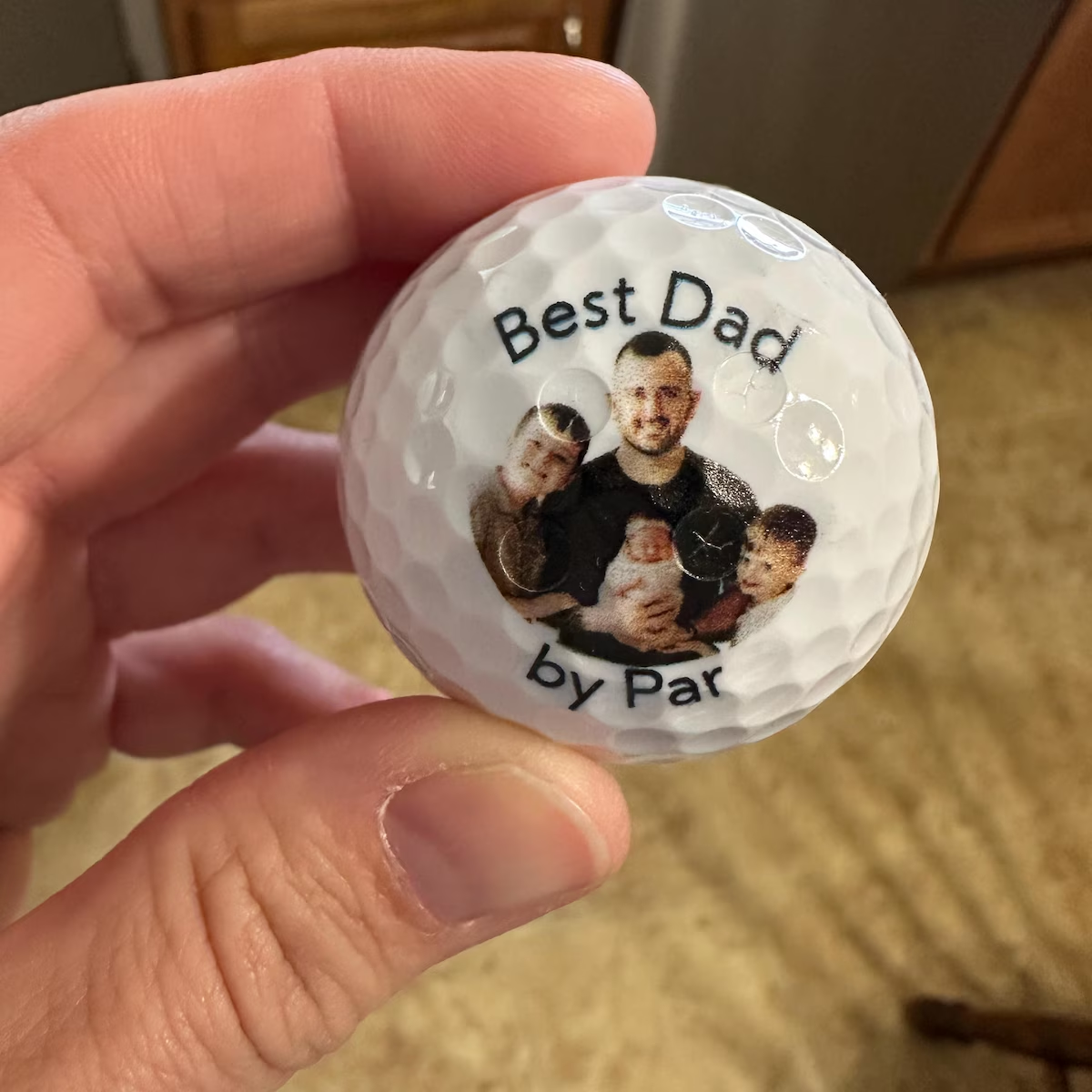 Best Dad by Par golf ball with a family photo, held in hand
